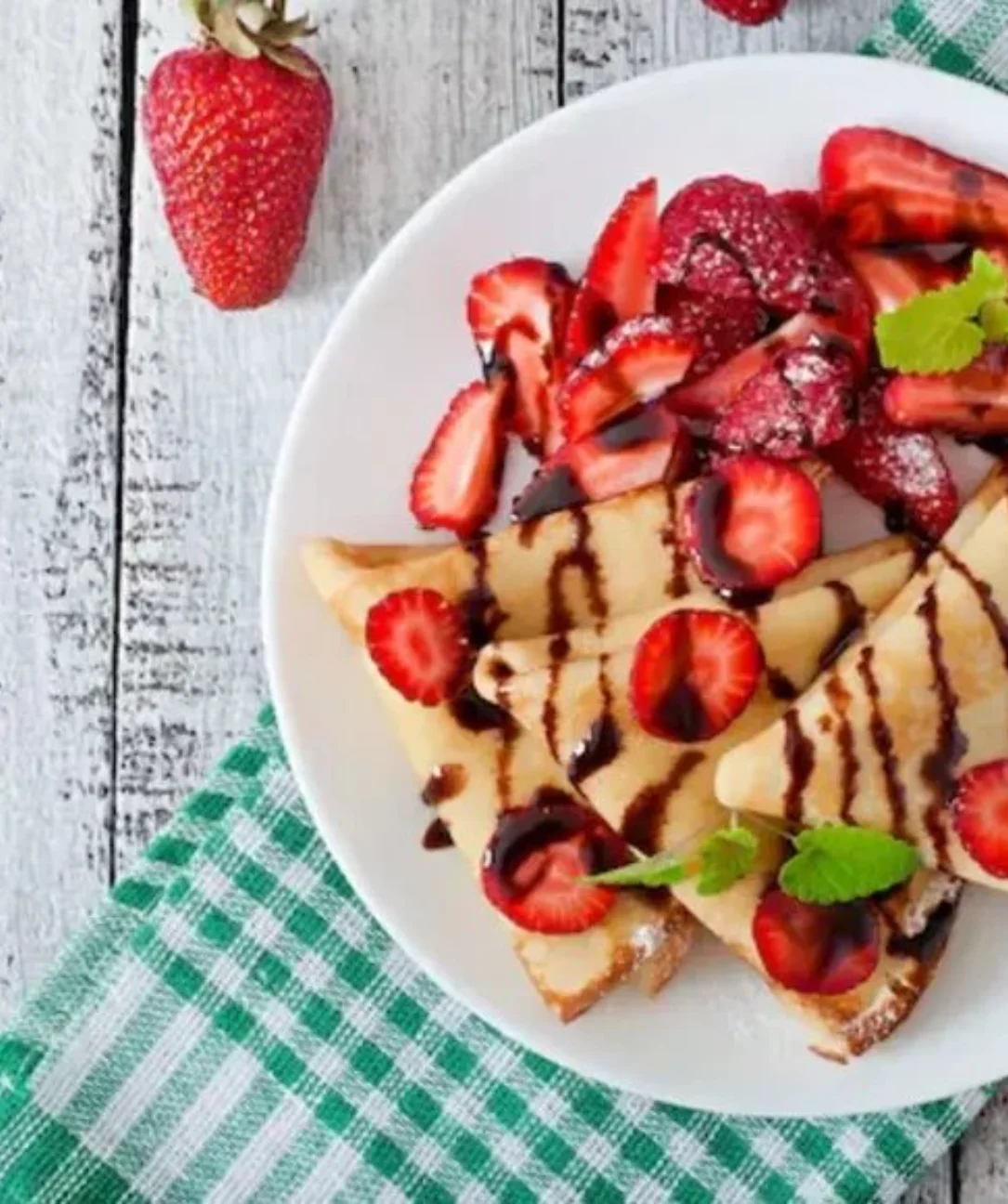 Strawberry crepe cookie topped with fresh strawberries and whipped cream